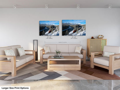 a modern living room with a large sofa, two chairs, and a coffee table. There are two framed landscape photographs hanging on the wall above the furniture.