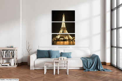 a living room with a white couch and three pictures of the eiffel tower