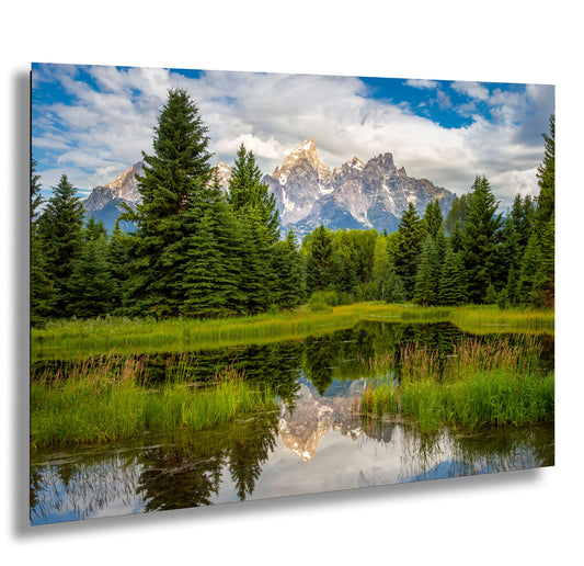 a mountain range is reflected in a pond