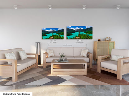 a modern living room with a large, colorful landscape painting hanging on the wall above a wooden coffee table. The room is furnished with a sofa, two armchairs, and a wooden cabinet. The overall design and decor create a cozy and inviting atmosphere.