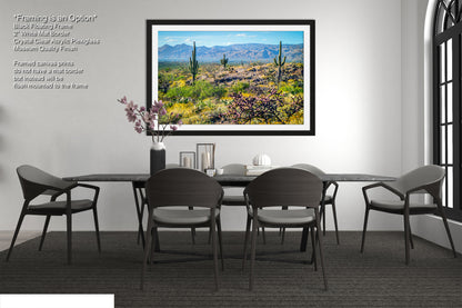a modern dining room with a large framed landscape painting hanging on the wall above a black dining table surrounded by six chairs.
