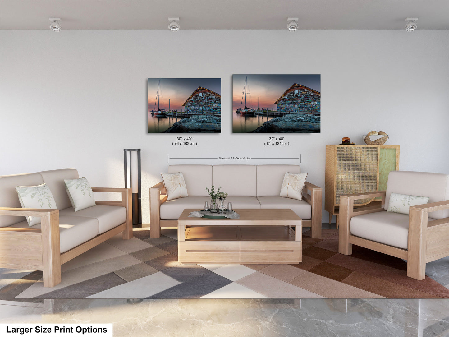 a modern living room with a large sofa, two chairs, and a coffee table. There are two framed prints of a seascape displayed on the wall above the furniture.