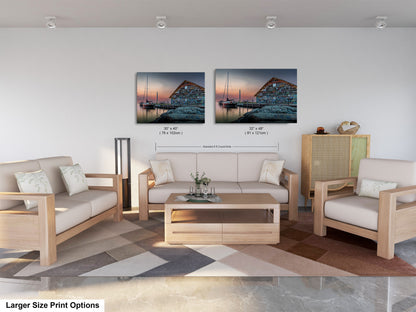a modern living room with a large sofa, two chairs, and a coffee table. There are two framed prints of a seascape displayed on the wall above the furniture.
