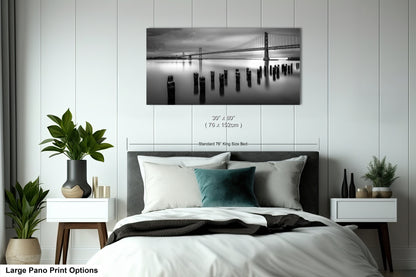 a black and white photo of a bed with a bridge in the background