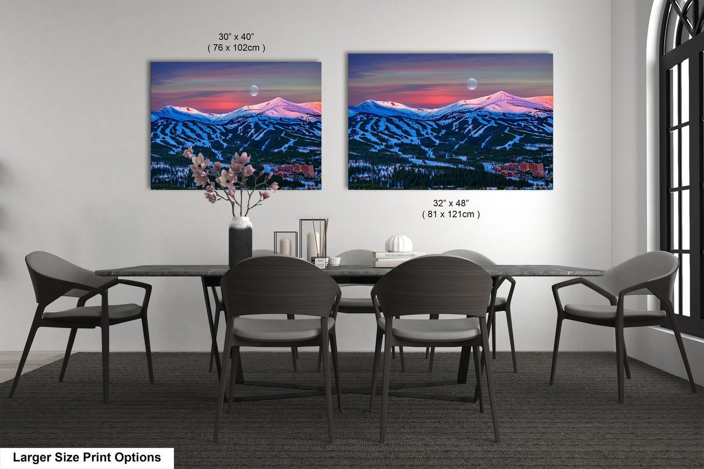 a dining table with four chairs and a vase with flowers