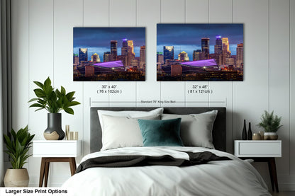 a bed with two pictures of a city at night
