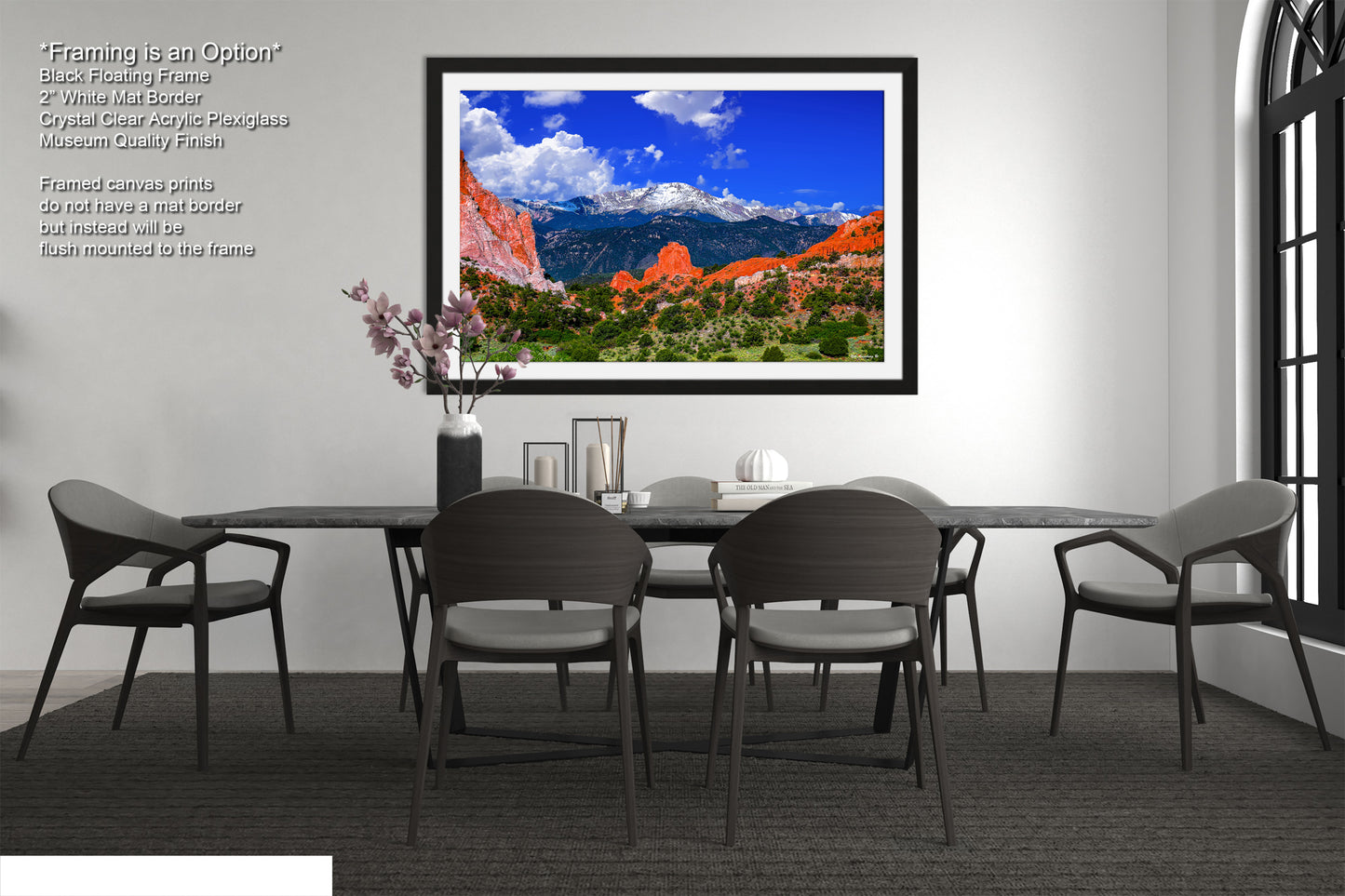 a dining room table with chairs and a picture hanging on the wall