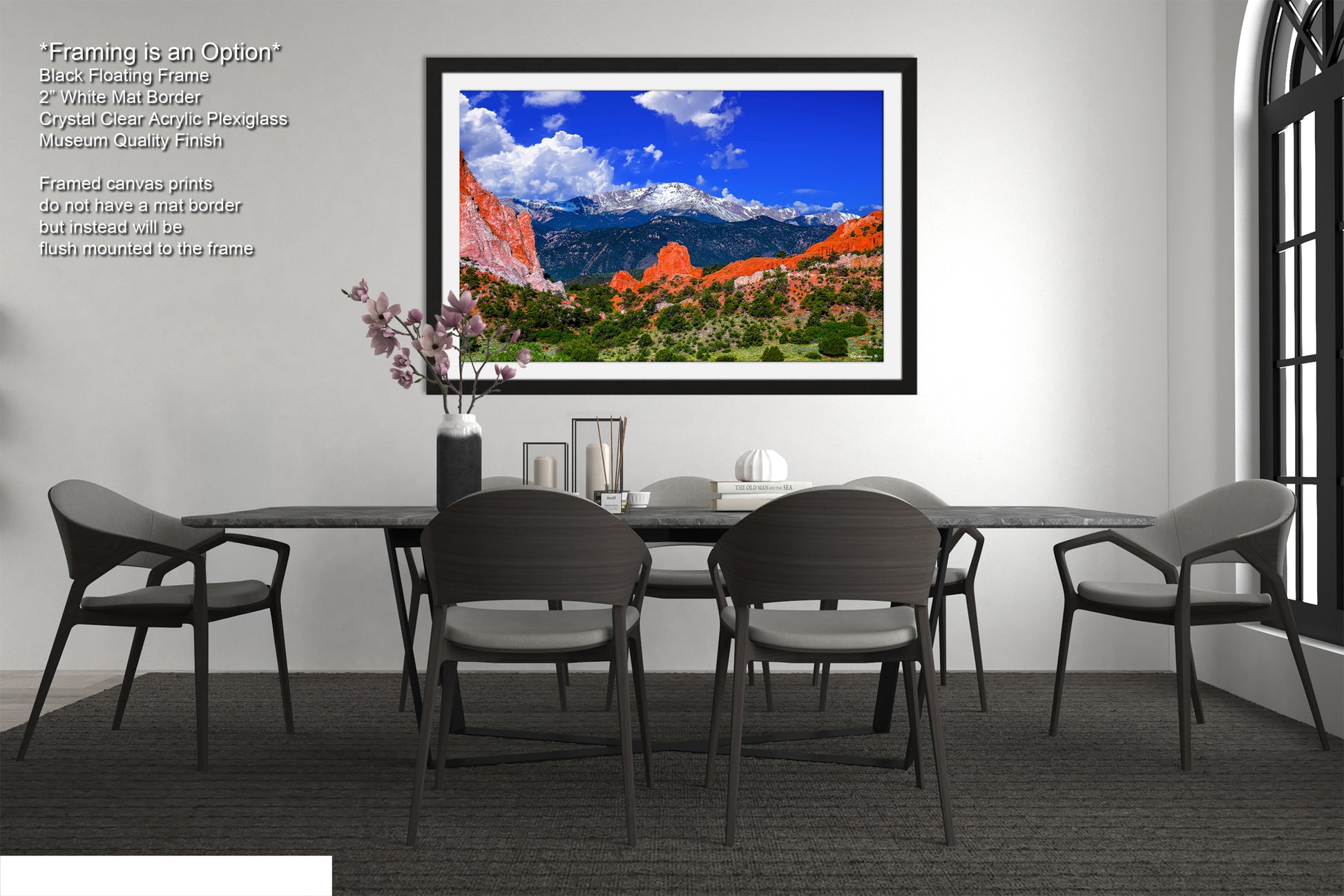 a dining room table with chairs and a picture hanging on the wall