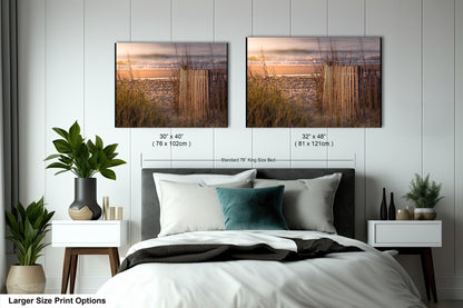 a bed with two pictures hanging above it