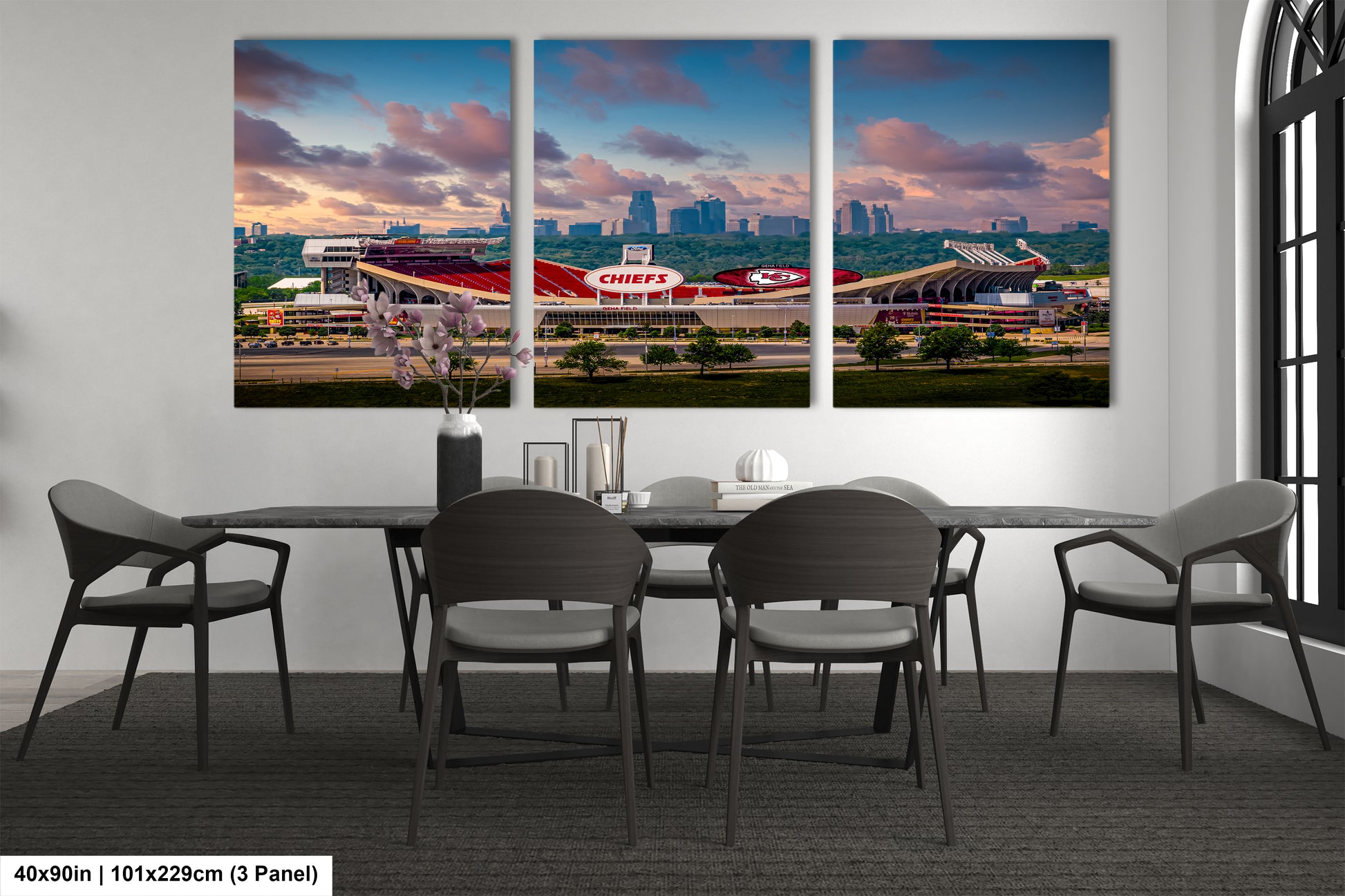 a dining room table with four chairs and a large picture of a stadium
