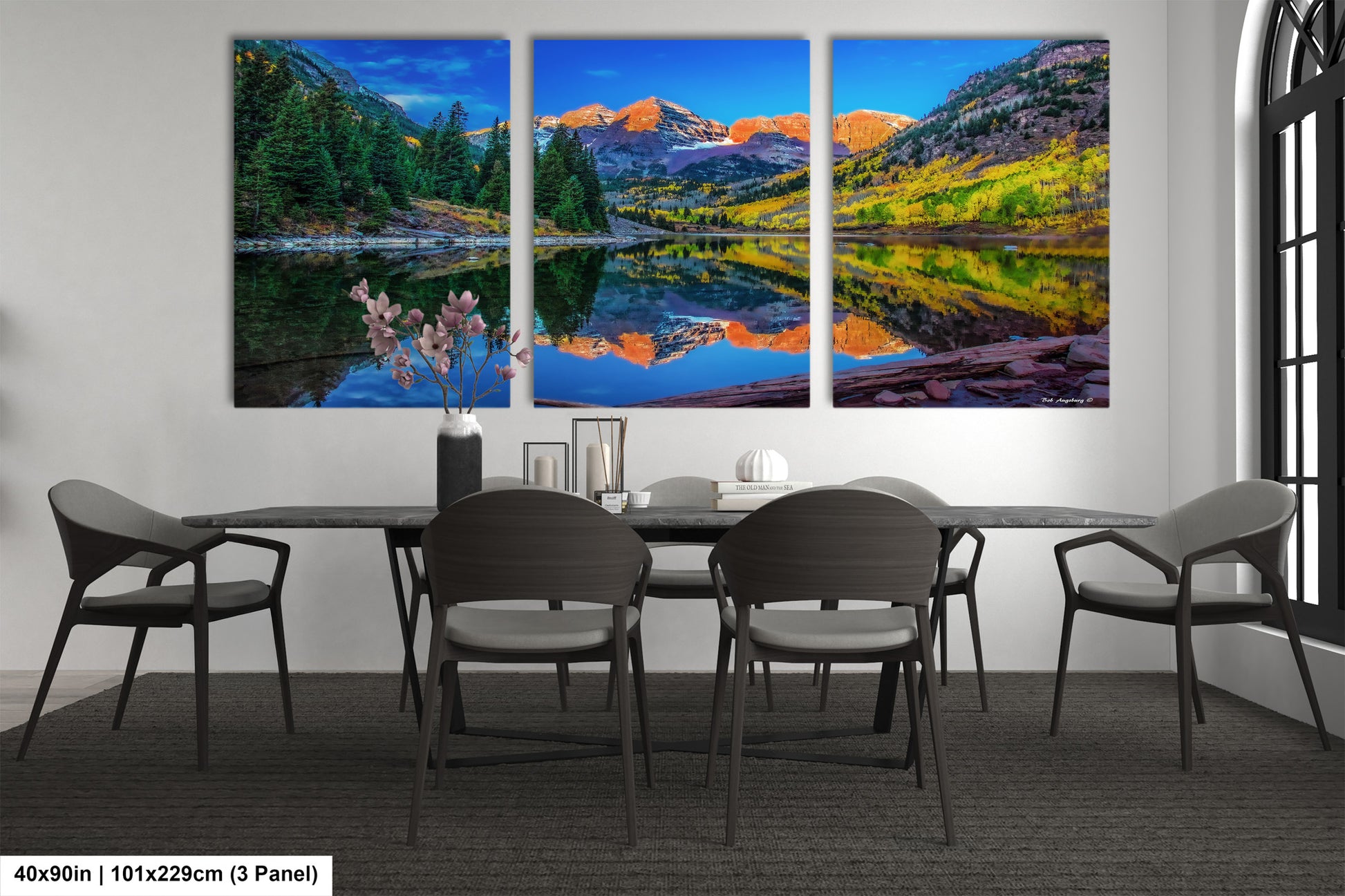 a dining room table with four chairs and a painting on the wall