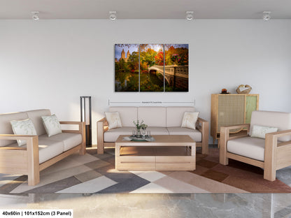 The image is a modern living room with a large, colorful painting of a scenic landscape hanging on the wall. The painting features a bridge, trees, and a body of water, creating a serene and picturesque atmosphere. The room is furnished with a sofa, two chairs, and a coffee table, providing a comfortable and inviting space for relaxation and socializing.