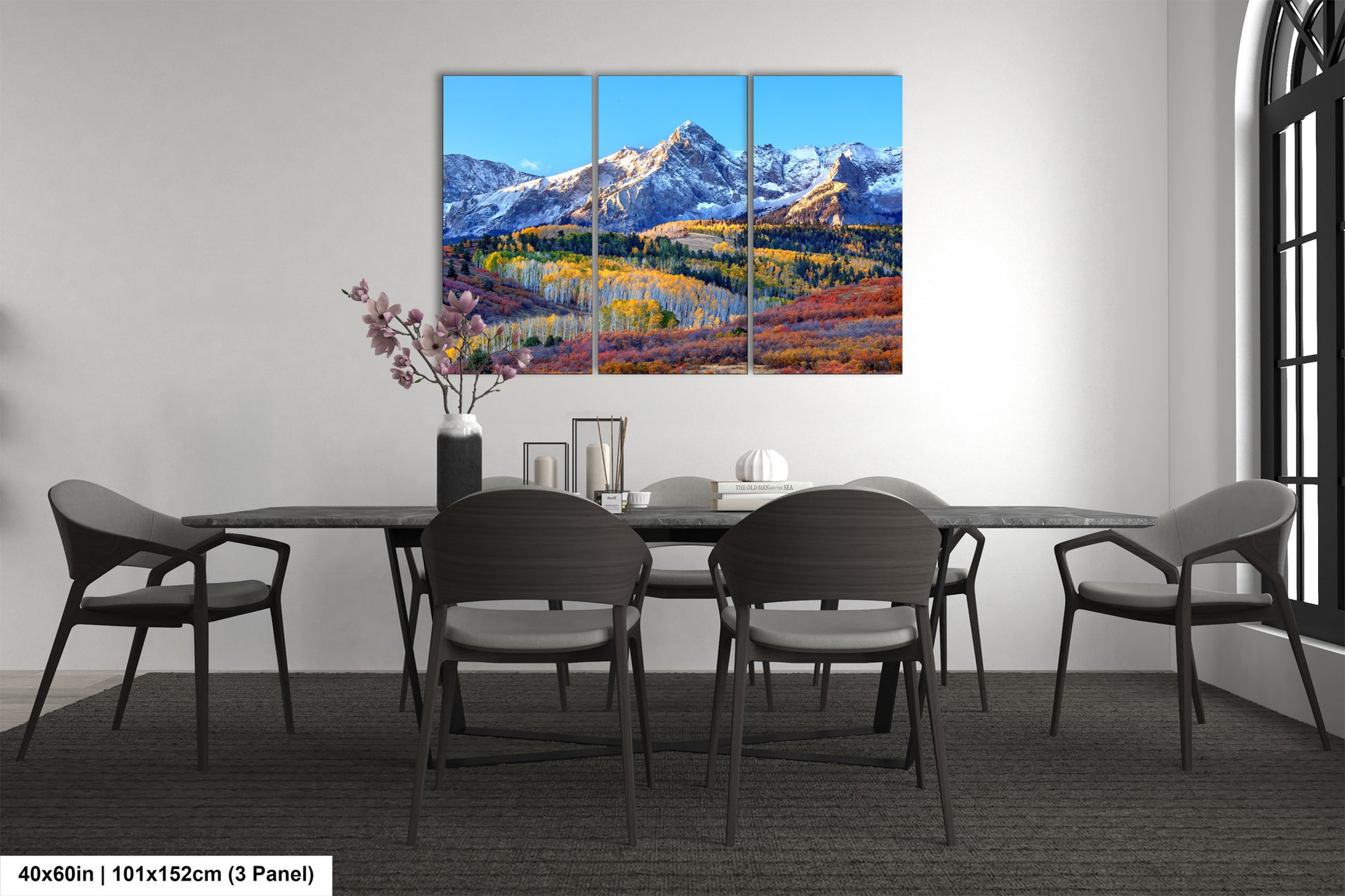 a dining room table with four chairs and a painting on the wall
