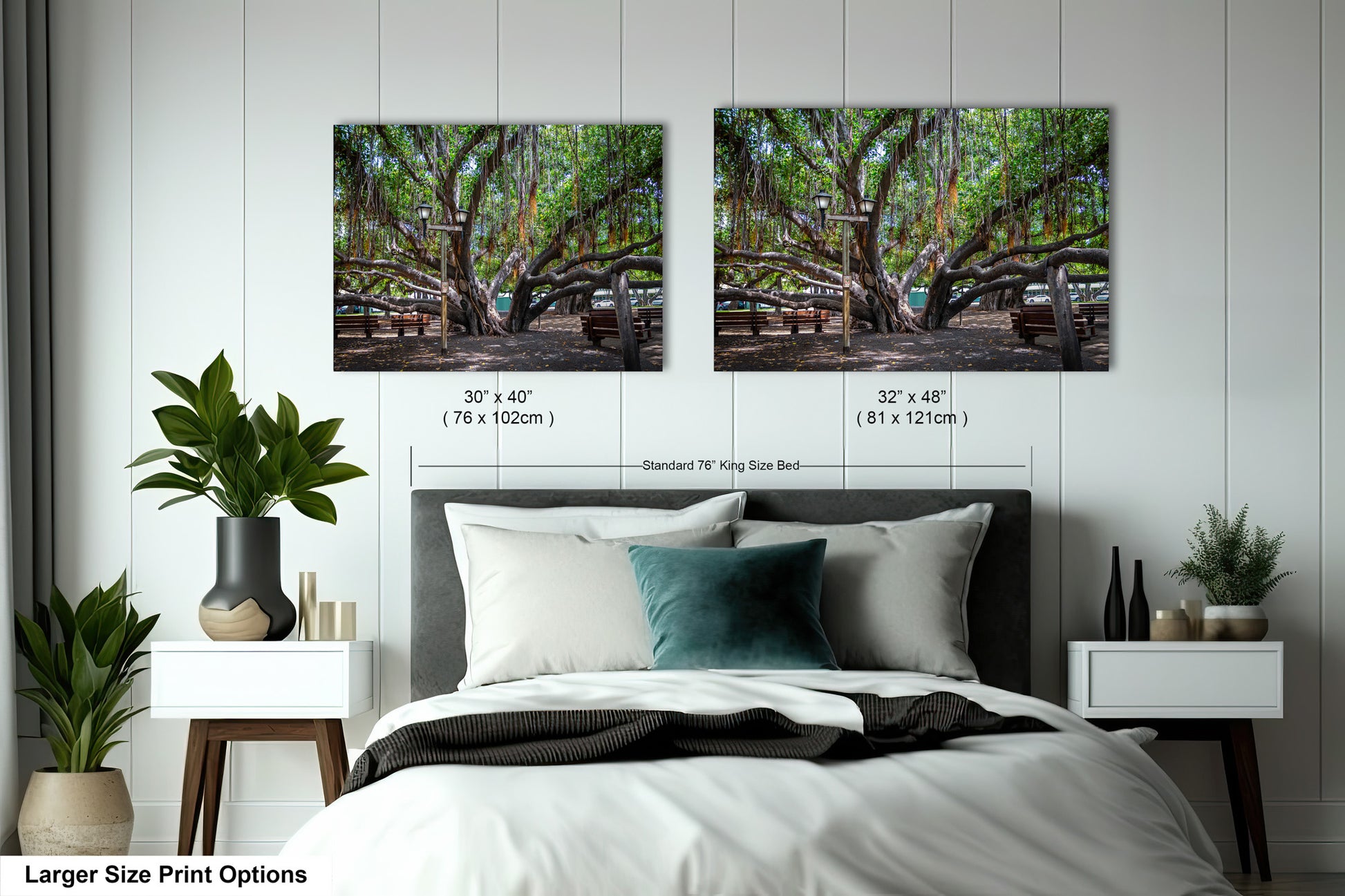 a bed with two pictures of trees on the wall above it