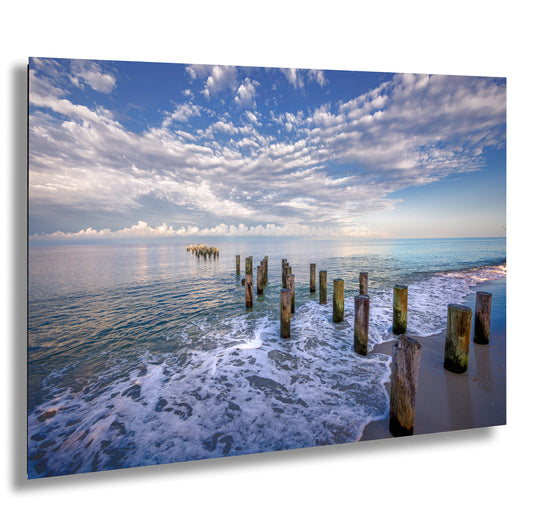 a picture of the ocean with a pier sticking out of the water