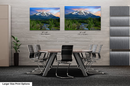 a dining room table with chairs and two pictures of a mountain