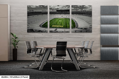 a dining room table with chairs and a wall mounted picture of a football stadium