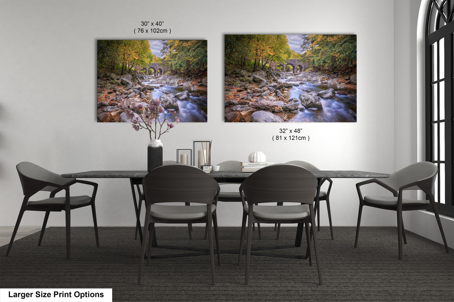 a dining room table with four chairs and two pictures on the wall