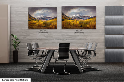 a dining room table with chairs and two pictures on the wall