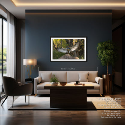 a modern living room with a large framed artwork of a bird in flight hanging on the wall. The room features a gray sofa, a wooden coffee table, and a large window overlooking a natural outdoor scene.