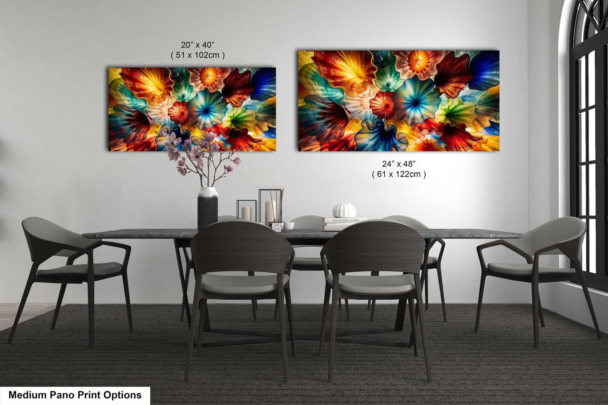 two large, colorful paintings of flowers hanging on a wall above a dining table with chairs.