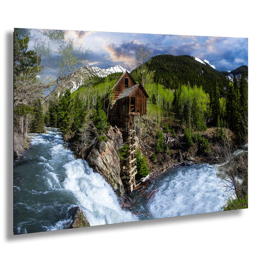 a painting of a cabin on a cliff next to a river