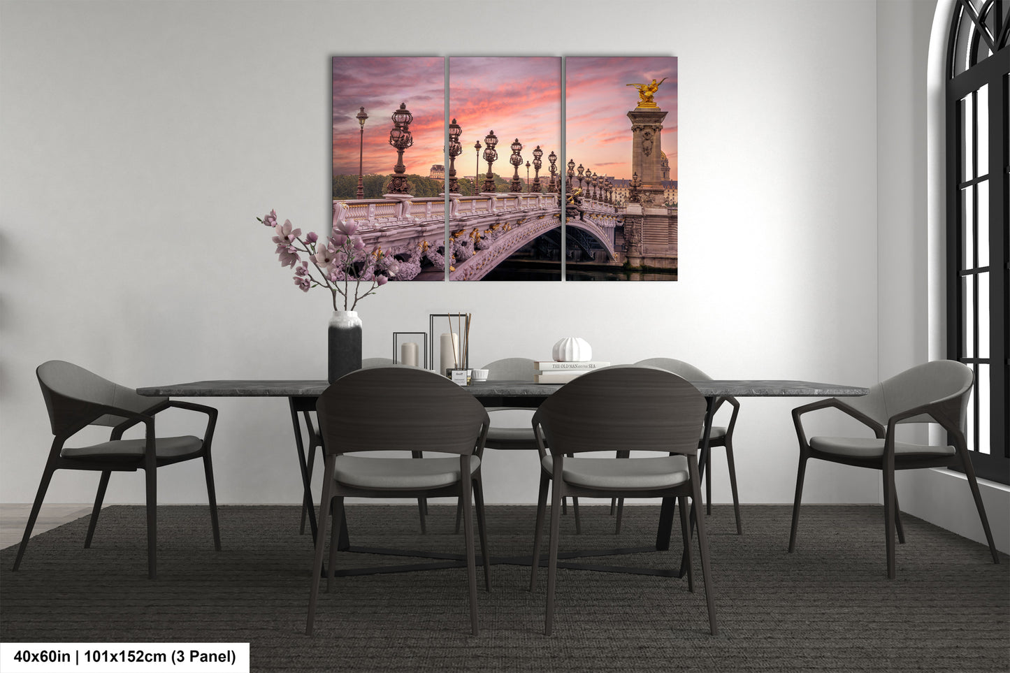 a dining room table with chairs and a painting on the wall
