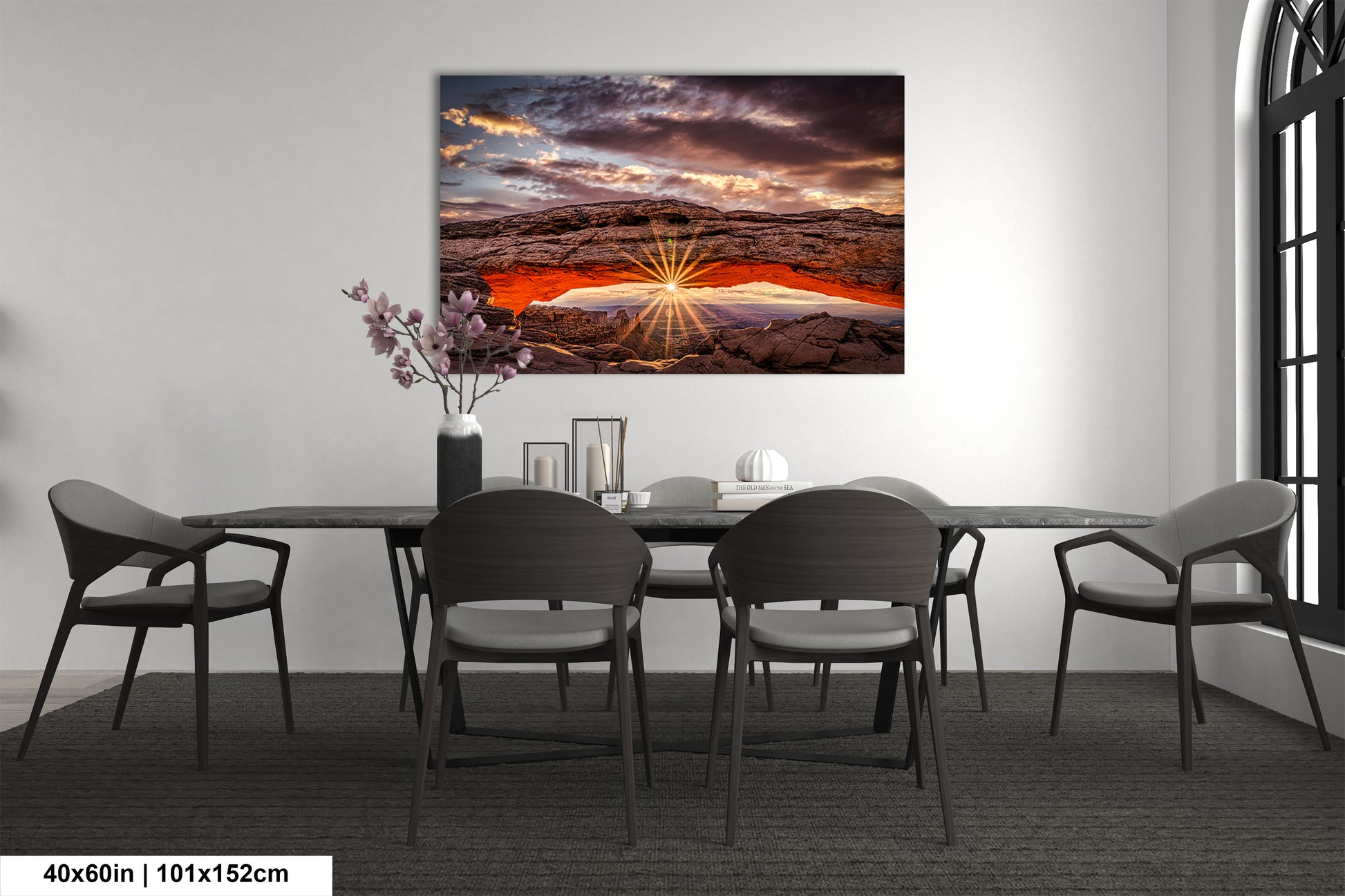 a dining room table with chairs and a painting on the wall