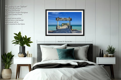 a bedroom with a bed and a picture hanging on the wall
