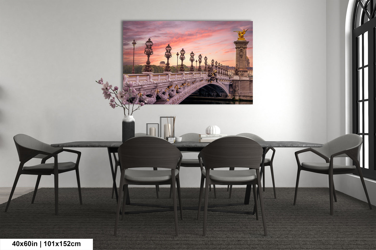 a dining room table with chairs and a painting on the wall