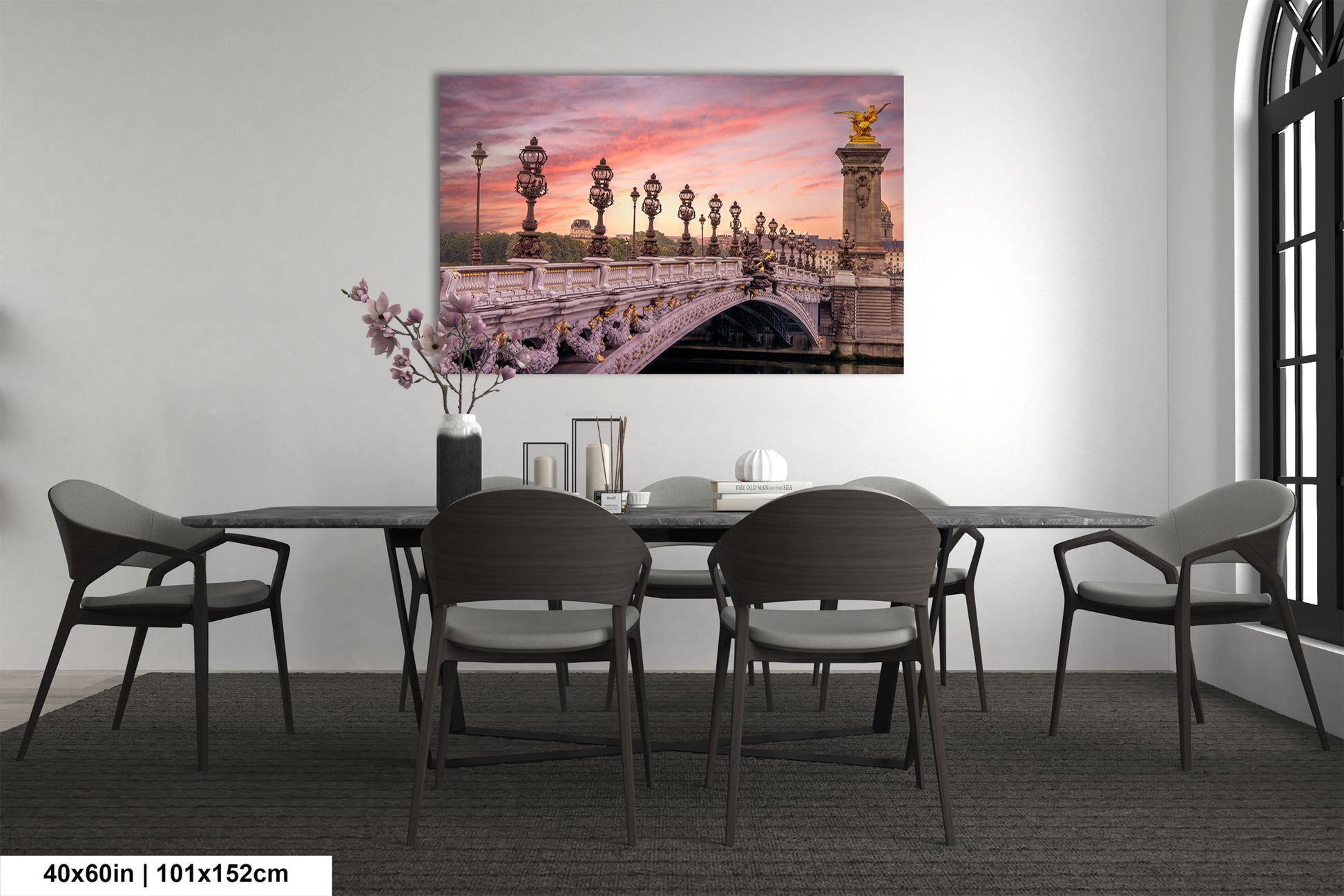 a dining room table with chairs and a painting on the wall