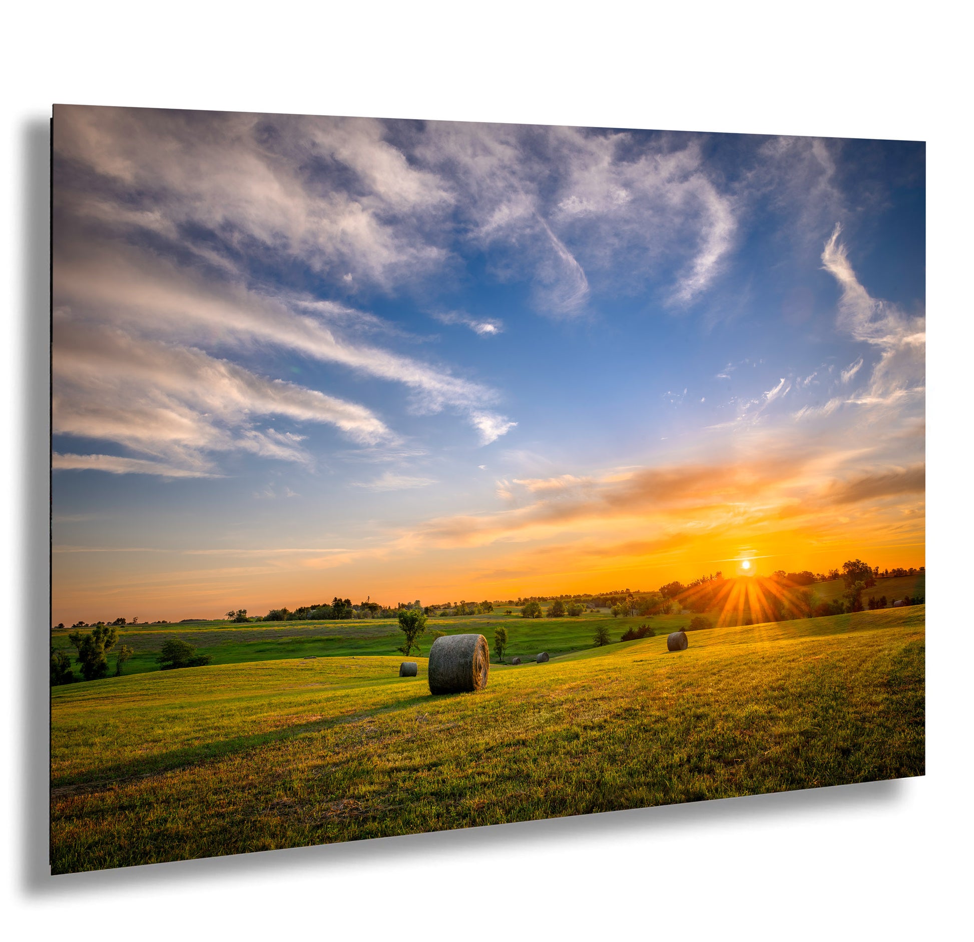 a field with hay bales at sunset