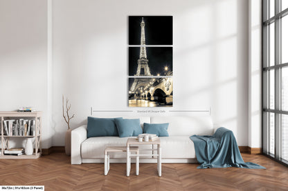 a living room with a white couch and a painting of the eiffel tower
