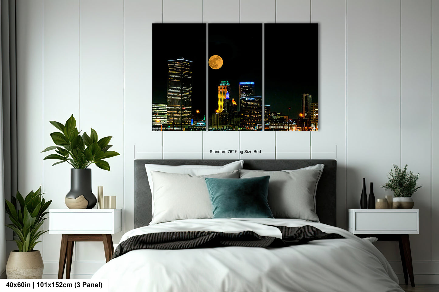a bedroom with a bed and a night view of a city