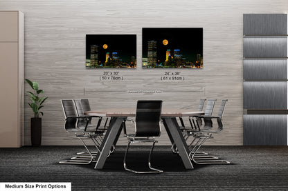a dining room table with chairs and two pictures of a city at night
