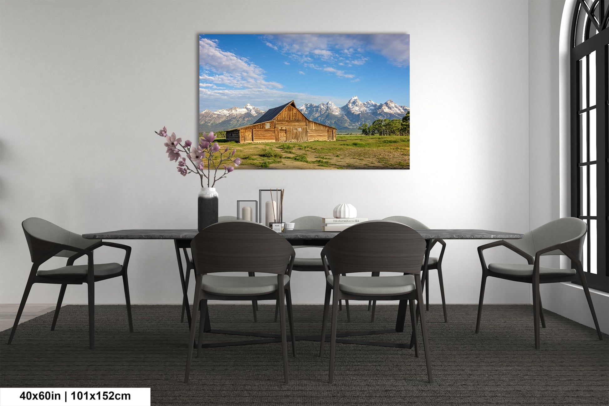 a room with a table and chairs and a painting on the wall