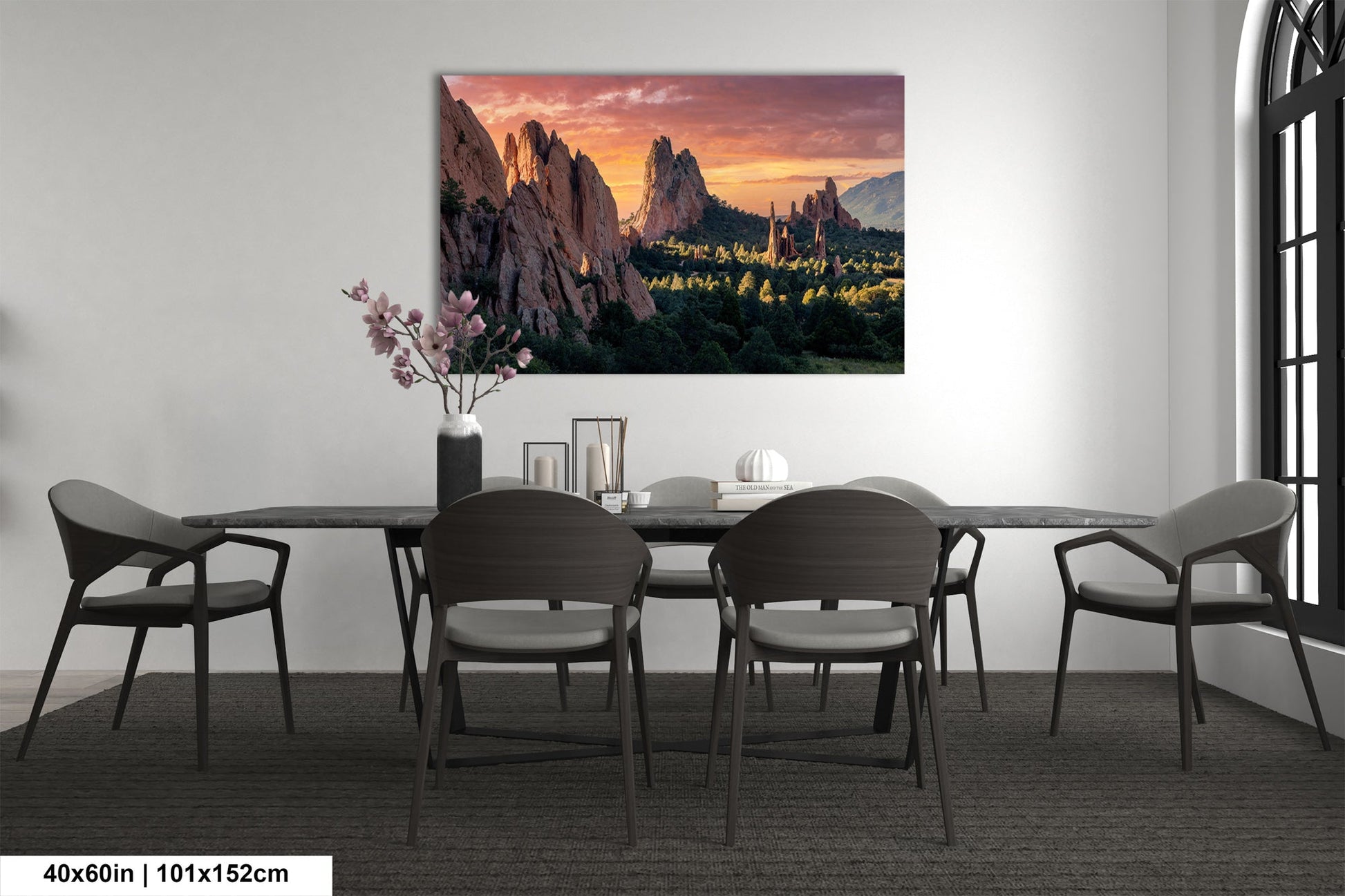a dining room table with chairs and a painting on the wall
