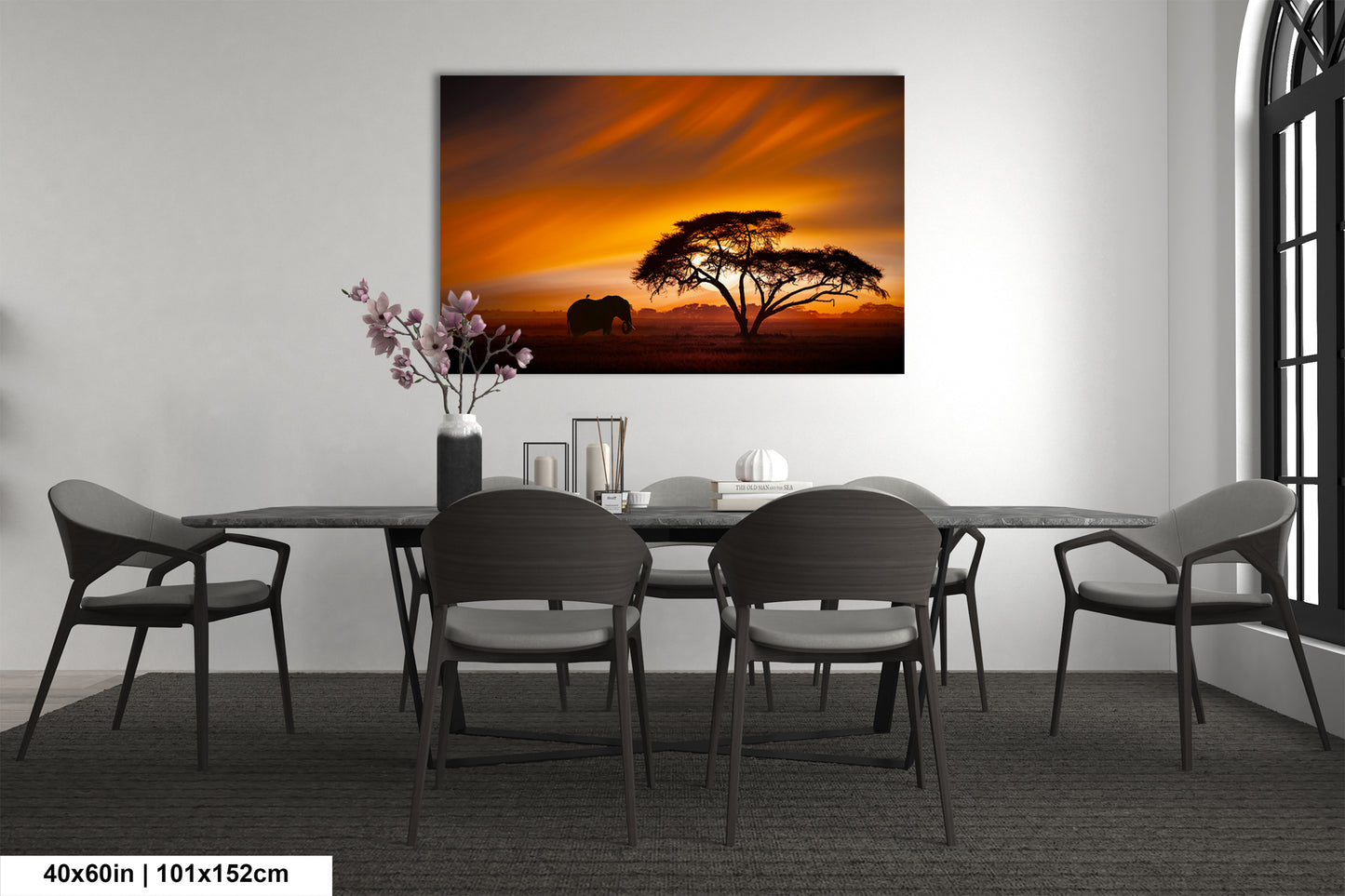 a dining room table with chairs and a painting on the wall