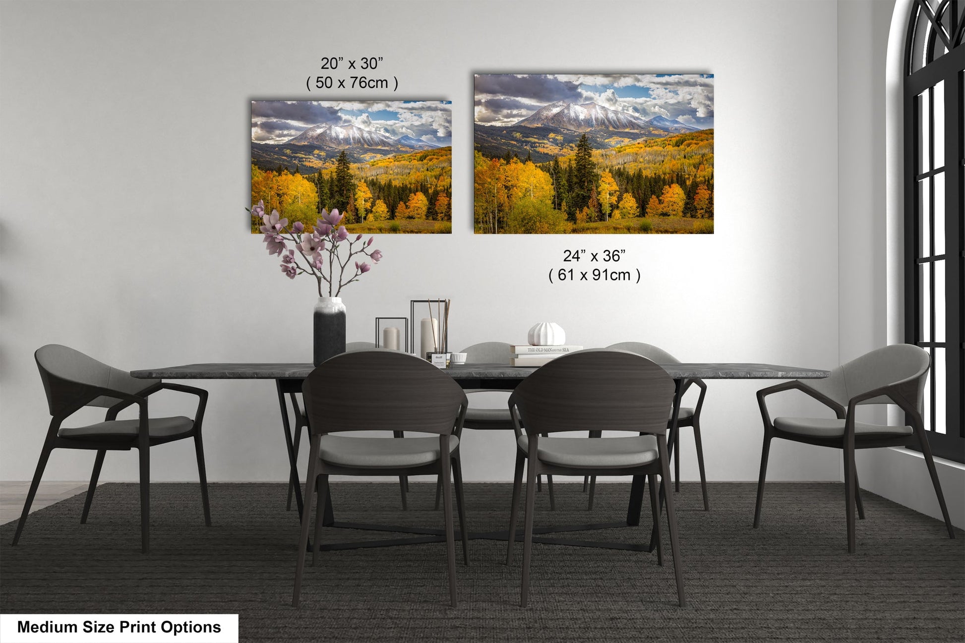 a dining room table with four chairs and a vase of flowers