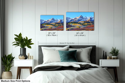 a bedroom with a bed and two pictures on the wall