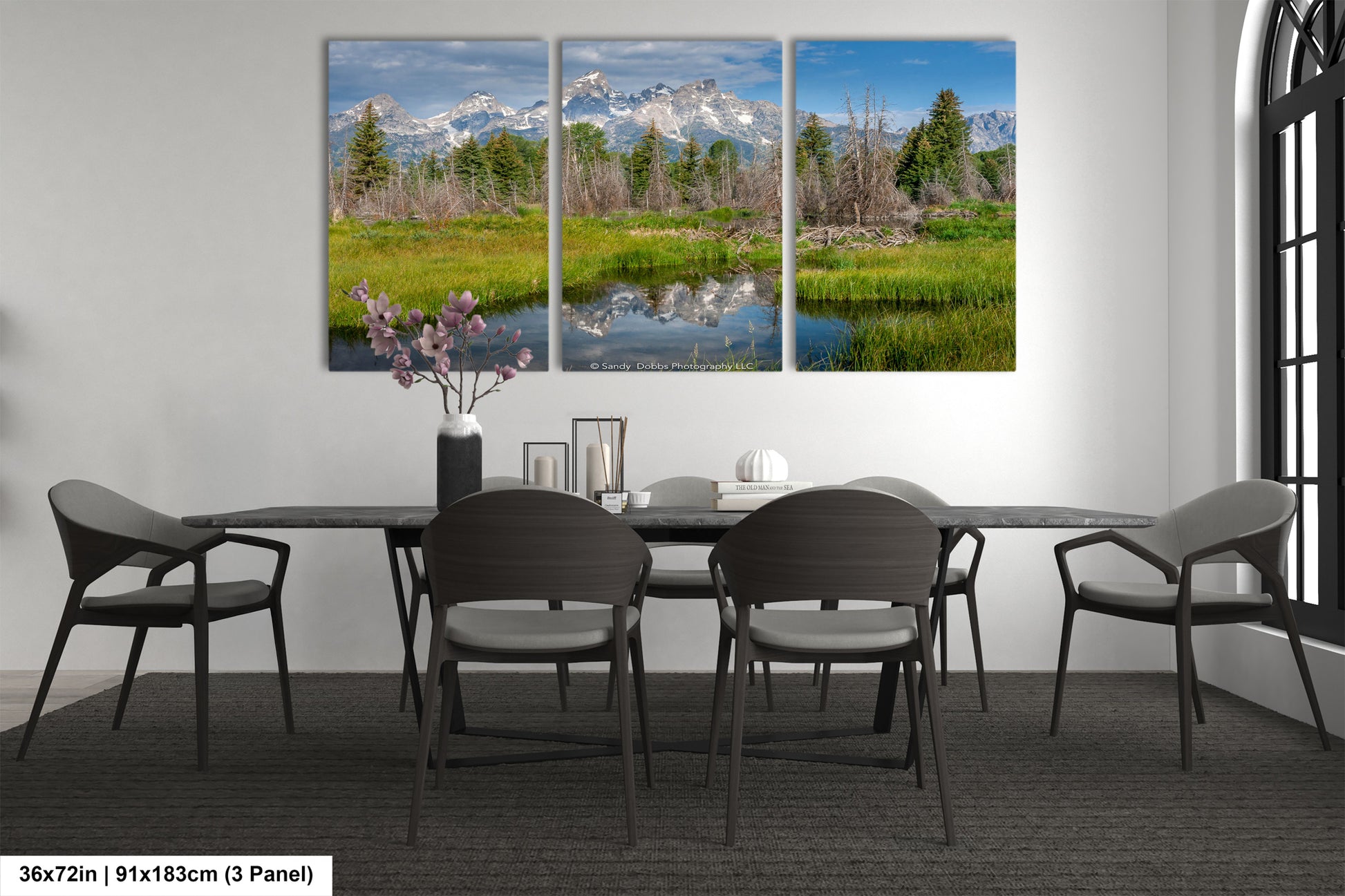 a dining room table with four chairs and a painting on the wall