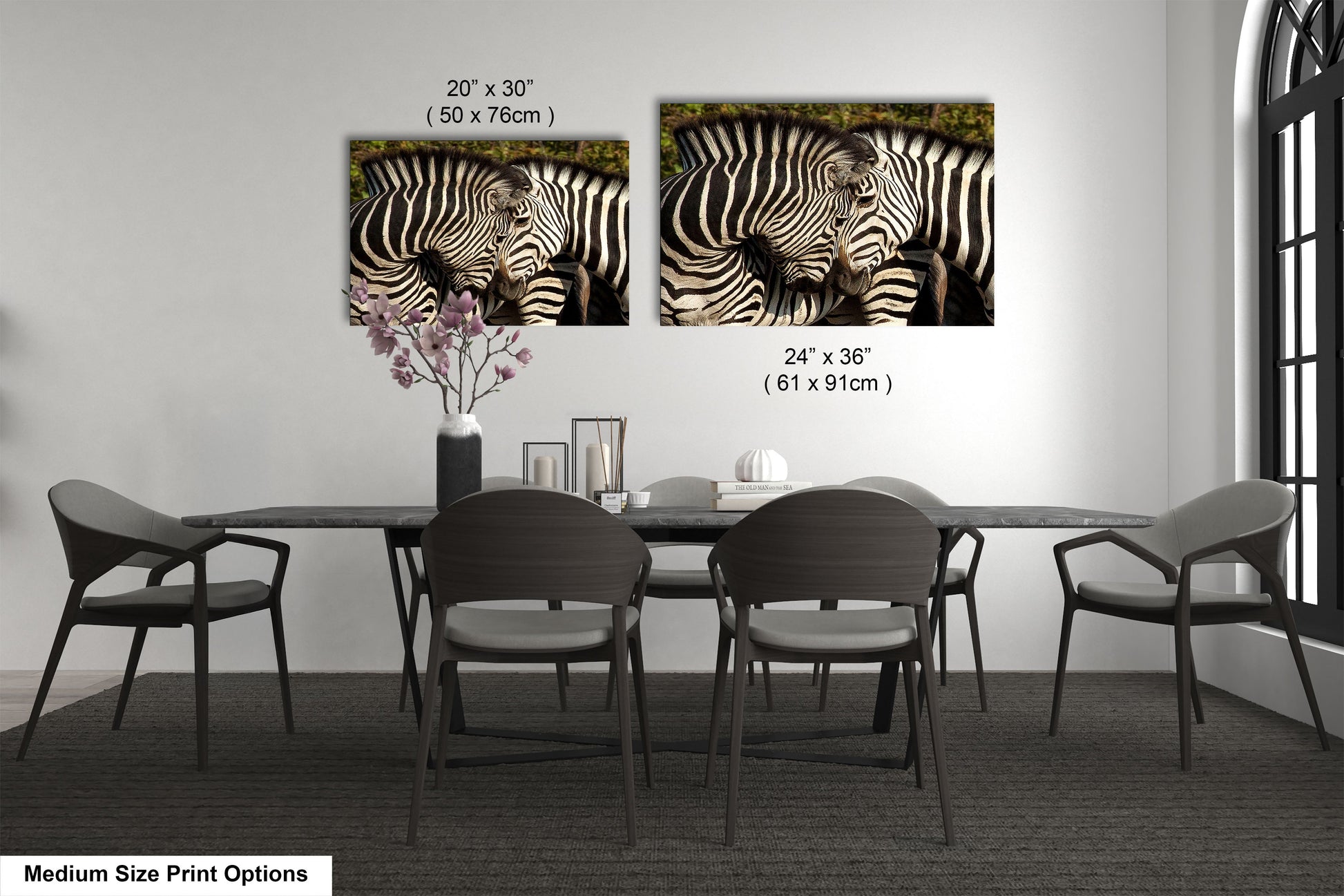 a dining room table with four chairs and two pictures of zebras on the wall