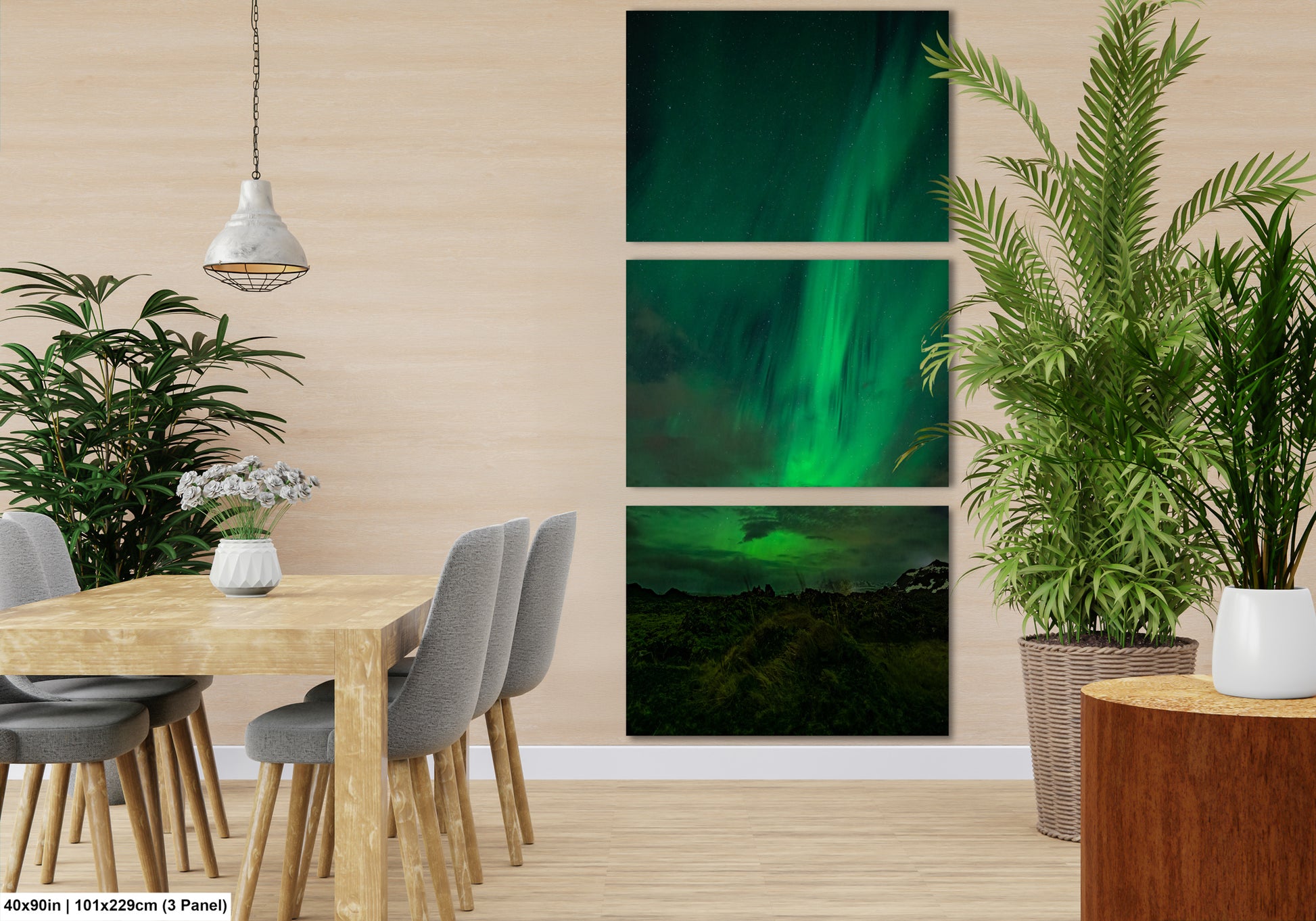 The image is a modern dining room with a wooden table and chairs, a hanging light fixture, and a large potted plant. The wall behind the table features three separate images of the Aurora Borealis, or Northern Lights, creating a visually striking and nature-inspired atmosphere.