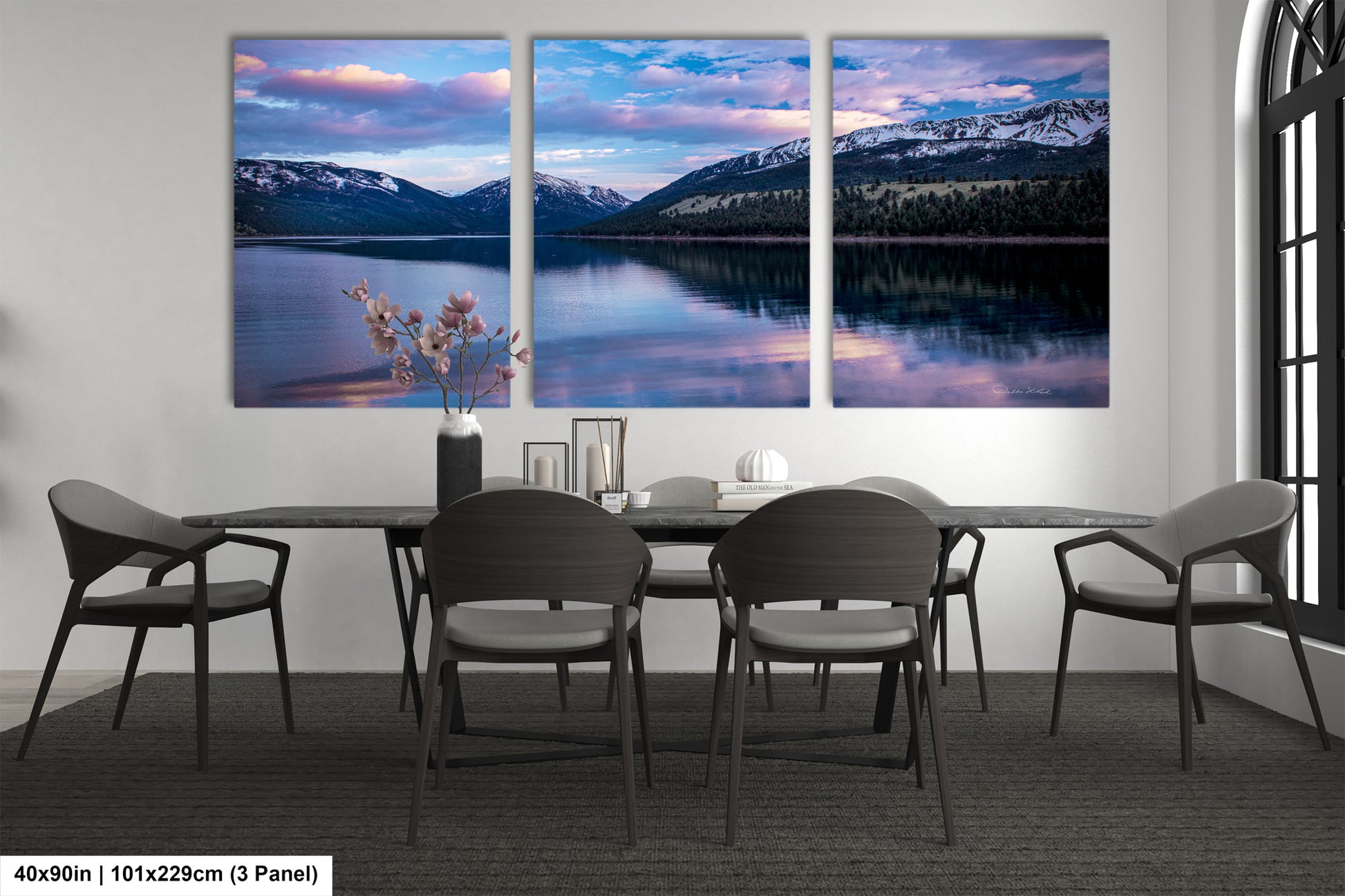 a dining room table with four chairs and three paintings on the wall
