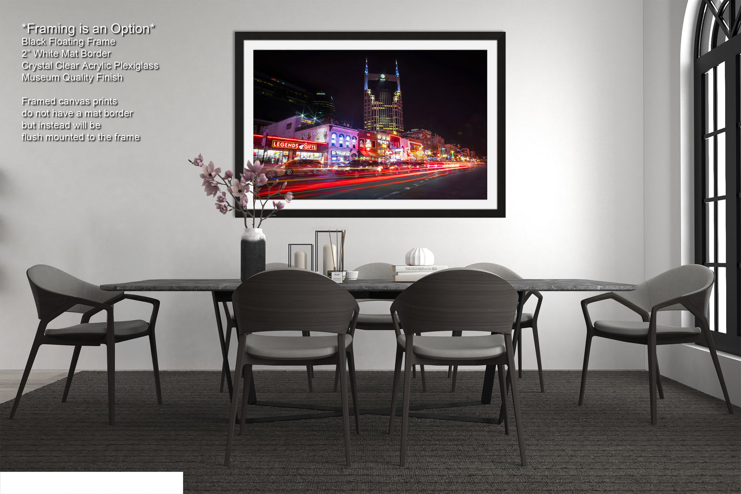 a dining room table with chairs and a picture hanging on the wall