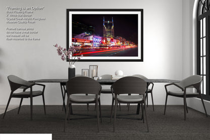 a dining room table with chairs and a picture hanging on the wall