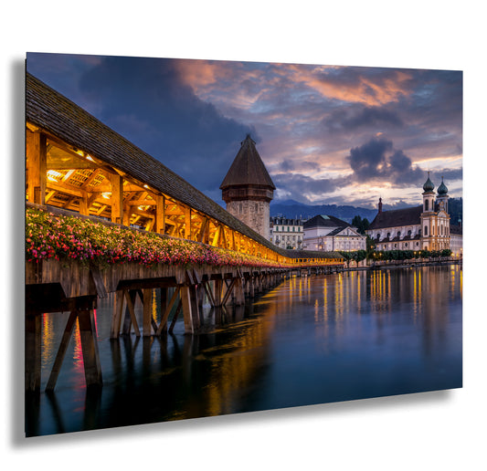 a wooden pier with flowers on it and a building in the background
