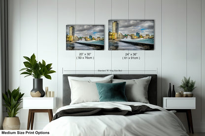 a bed room with a neatly made bed and two pictures on the wall