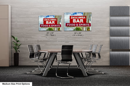 a dining room table with chairs and two signs on the wall