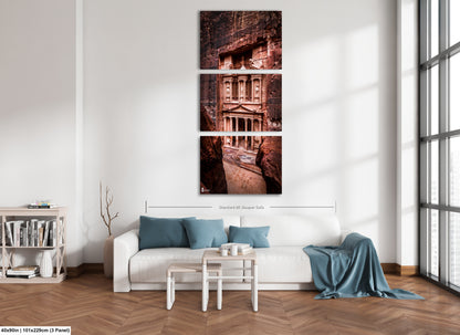 a living room with a white couch and three pictures on the wall